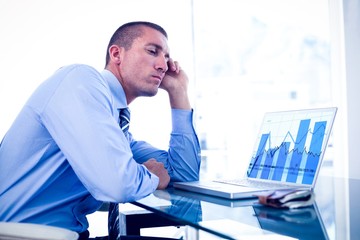 Poster - Composite image of tired businessman looking at his laptop