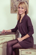 © khosrork - Beautiful young fashion 30-35 years blonde model in brown dress and black shoes and makeup and hairstyle and fair hair posing near the secretaire and looking at camera in provence design interior.