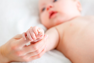 concept of parental love. baby hand holding finger of mother
