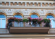Balcony with flowers and facade of the building in classical sty