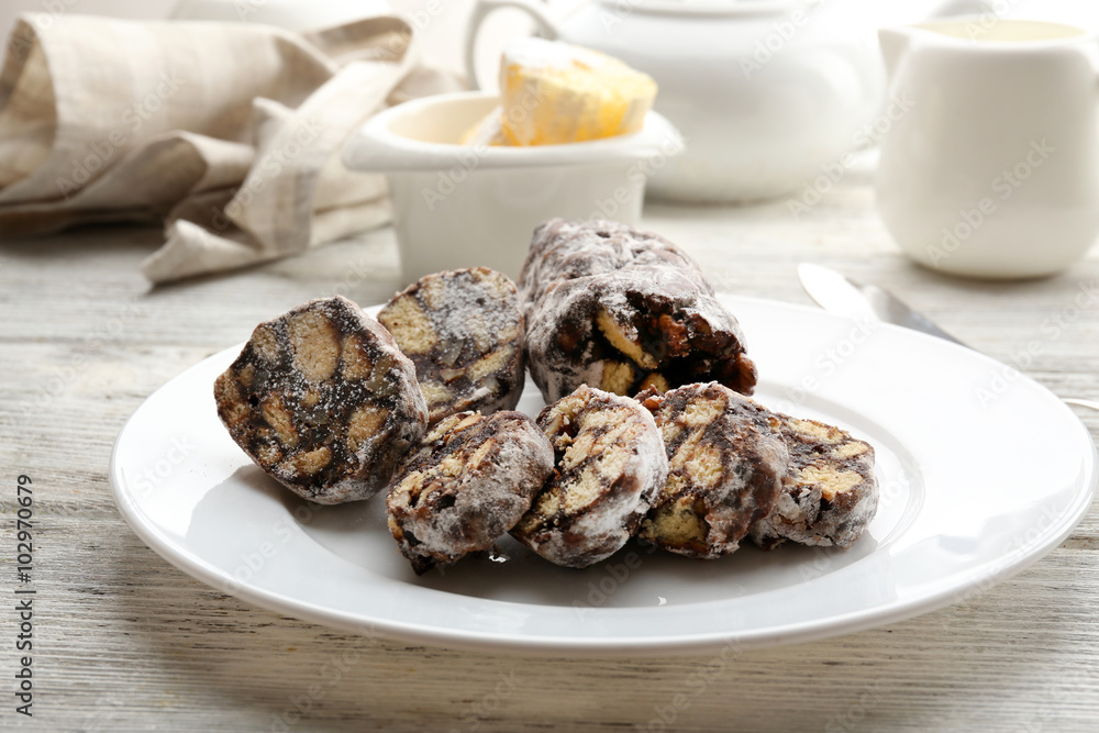 Chocolate salami in a plate over wooden background