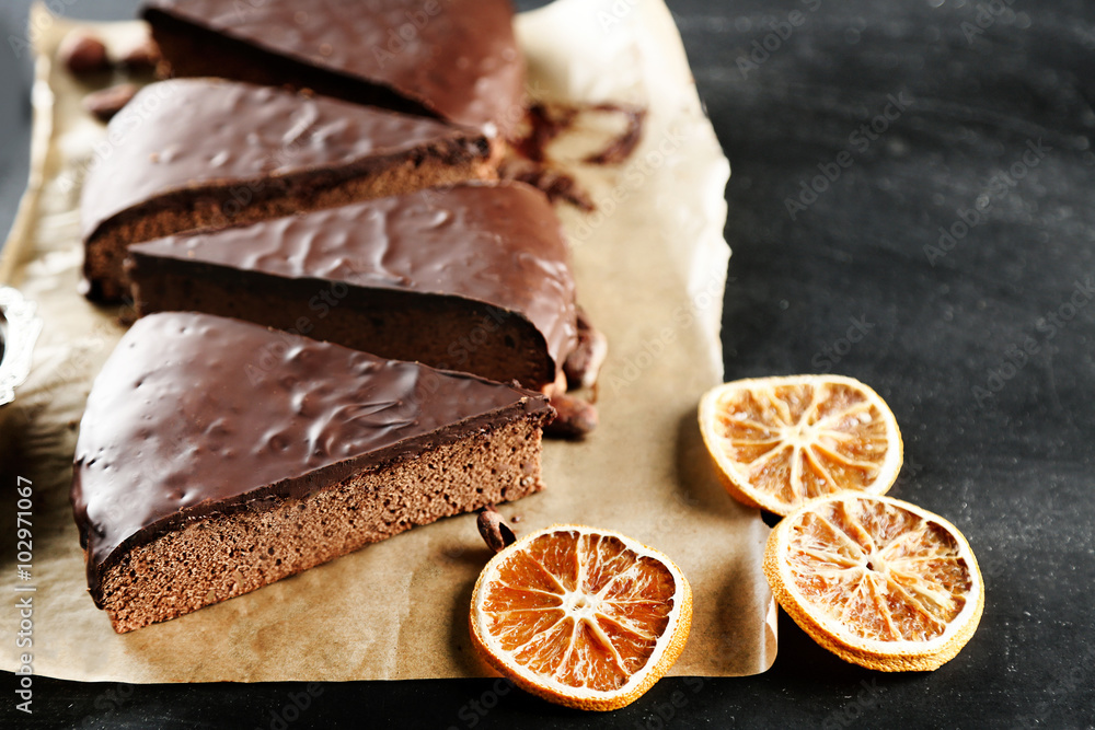 Pieces of frosting chocolate cake on parchment paper