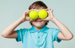 © zdyma4 - Little boy holding tennis balls instead of the eyes, smiling