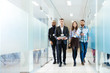 Group of happy young business people walking in office together