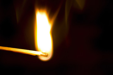 burning matchstick on black background