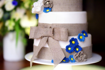 Canvas Print - Three stories wedding cake decorated with blue flowers