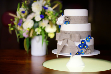 Wall Mural - Three stories wedding cake decorated with blue flowers