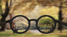 Closeup On Eyeglasses With Focused And Blurred Landscape View.