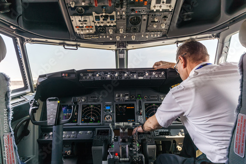 Poster Pilot in the cockpit of a passenger plane