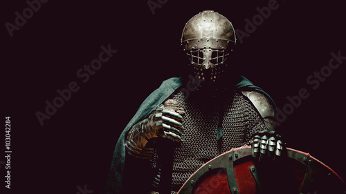 Plakat Średniowieczny rycerz w zbroi z mieczem i tarczą.