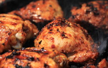 Delicious And Juicy Seasoned Chicken Thighs Being Cooked On A Charcoal Barbeque Grill
