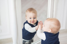 Ten Month Boy Stands Before The Mirror