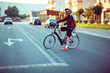 © vladstar - Young man in sunglasses riding a bike on city street