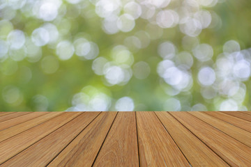 Wall Mural - wooden platform beside abstract blurred foliage background