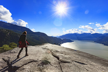 woman hiking over the top of a mountain