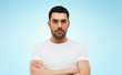 © Syda Productions - young man with crossed arms over blue background