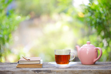 pink vintage  teapot  with a cup of glass tea and notebooks with flower 