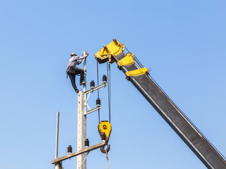 Canvas Print - Electrician working on electricity power pole with crane.