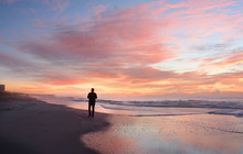 Man Relaxing On The Beach At Sunrise, Atlantic Beach, North Carolina.