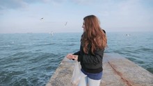 Young Woman Feeding A Seagulls At The Sea Pier, Slow Motion
