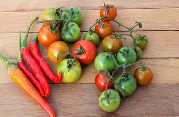 Fresh red tomatoes and peppers Placed on a wooden table