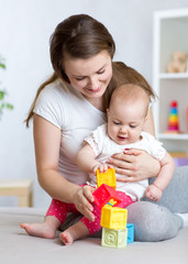 Mother and baby girl playing with developmental toys in living room