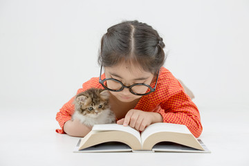 Wall Mural - Little Asian girl reading a book with lovely Persian kitten on isolated