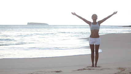 Wall Mural - Free woman enjoying freedom feeling happy at beach at sunset. Beautiful serene relaxing woman in pure happiness and elated enjoyment with arms raised outstretched up on Makena beach, Maui, Hawaii, USA