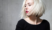 Close-up Portrait Of A Beautiful Blonde With Red Lips On A Black Background