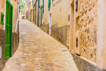 Fototapete - View of an mediterranean alleyway with rustic paving stones