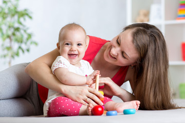 cute mother and baby play indoor at home