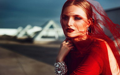 Gorgeous elegant woman in red long dress with diamonds on the roof