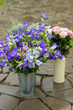 Buckets and cans with flowers. Blue bells and pink rose.