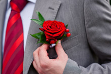 Groom In Red Tie With Rose On His Jacket
