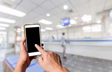 Man using touch screen mobile phone with blurry image of Office