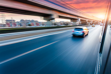 Wall Mural - Car driving on freeway at sunset, motion blur