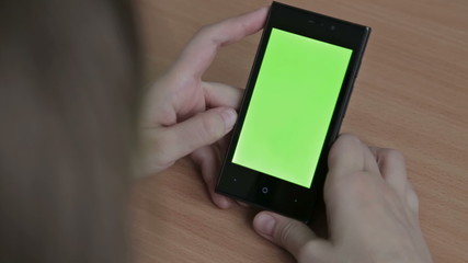 Female hands using cell phone, green screen