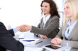 © rogerphoto - A group of business people at a meeting on the background of office. Business handshake. Focus on a beautiful blonde