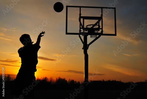 Fotomural Silueta del muchacho adolescente que tira un baloncesto