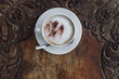Cappuccino with chocolate in white mug on vintage wood table