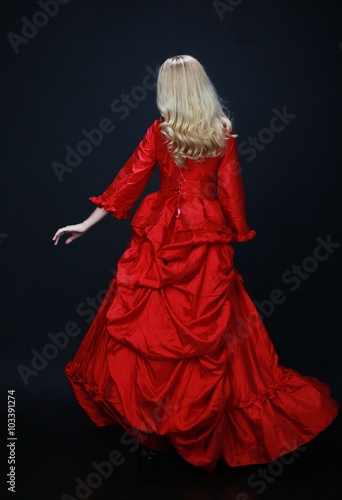 full length portrait of a beautiful blonde woman wearing a historical red silk, victorian era ball gown Canvas