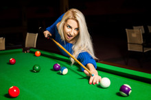 Angry Young Blonde Girl Plays Billiard At Pool Table