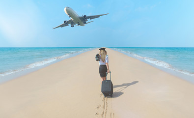 travel concept. young woman in flight attendant clothes walking on the beach with suitcase and hat .