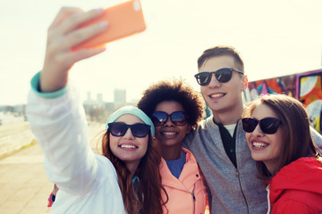 Wall Mural - smiling friends taking selfie with smartphone