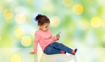 Wall Mural - smiling little baby girl playing with smartphone