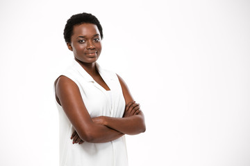 Smiling confident african american young woman standing with arms crossed