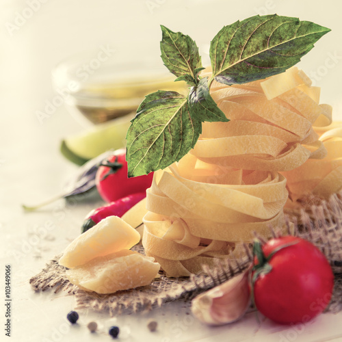 Fototapeta na wymiar Pasta and ingredients on rustic background