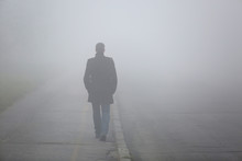 Man With His Back Walking Through The Fog Street