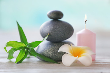 Wall Mural - Spa stones with candle, bamboo and tropical flower on blurred background