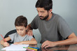 © kleberpicui - Young father and son drawing with colored pencils on the living